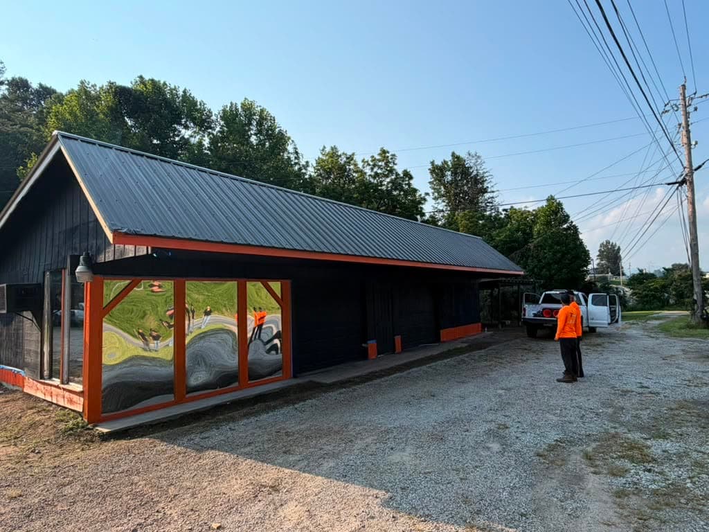 Traffik TTC crew member in hi-vis orange at the company yard with fleet trucks